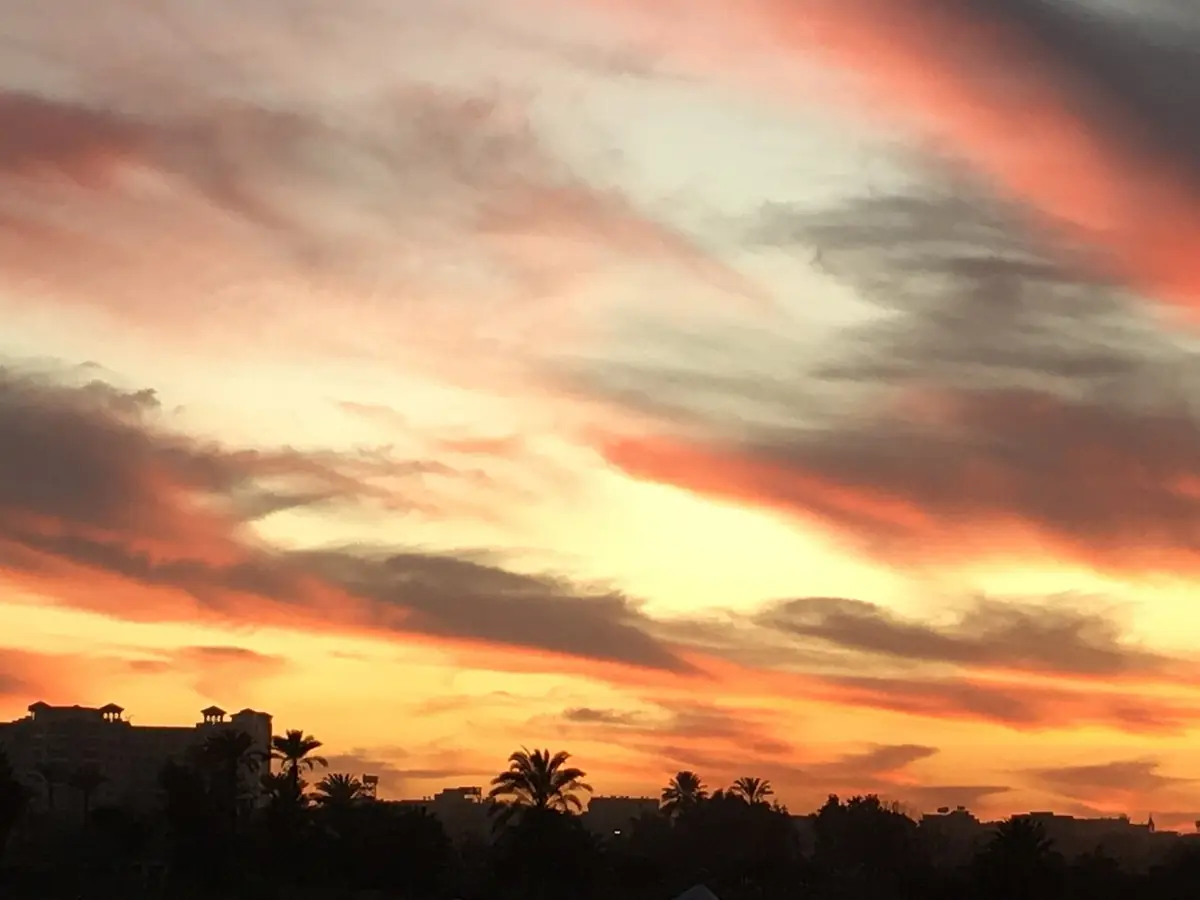 Un coucher de soleil aux nuages orangés au-dessus de Gizeh