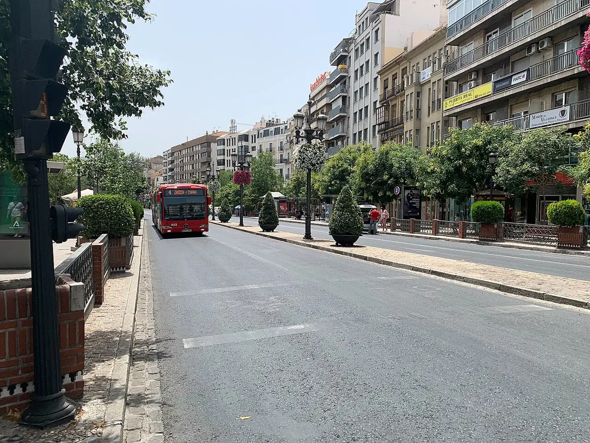 Un bus circule le long de l’Acera del Darro à Grenade, rue bordée d’immeubles