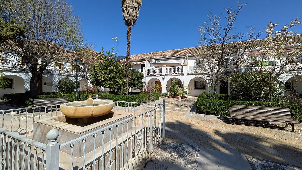 La Plaza Cardenal Cisneros à Grenade, jardin entouré d’arcades et de bâtiments anciens