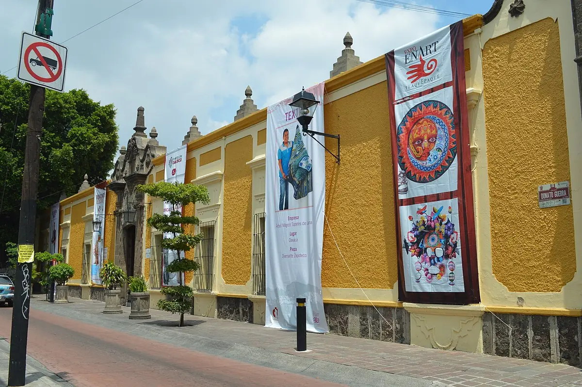 Une rue aux façades jaunes et aux palmiers dans un quartier de Guadalajara