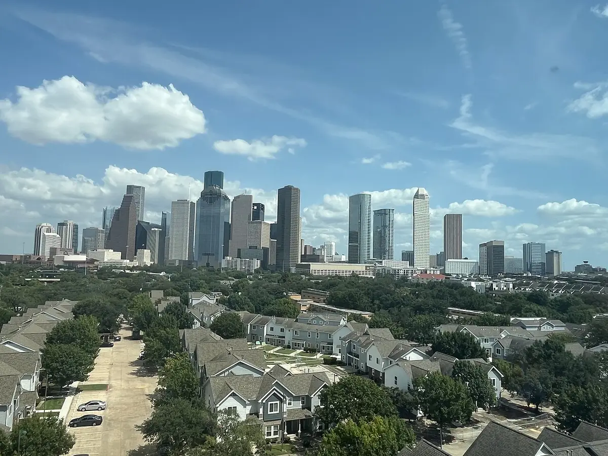 La skyline du centre-ville de Houston s’élevant au-delà d’un quartier résidentiel arboré