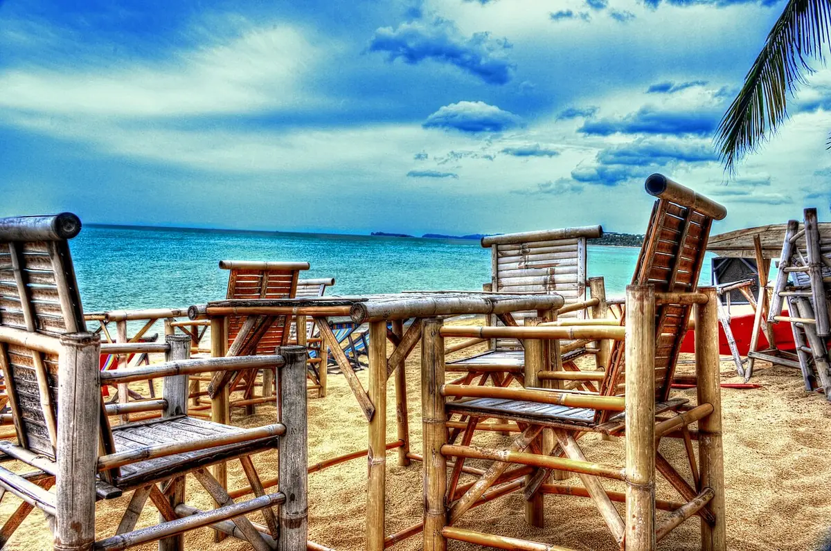 Chaises de plage en bois sur le sable face à la mer à Koh Samui