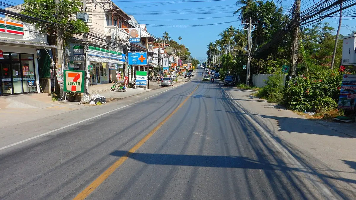 Une rue bordée de boutiques et d’une supérette à Koh Samui