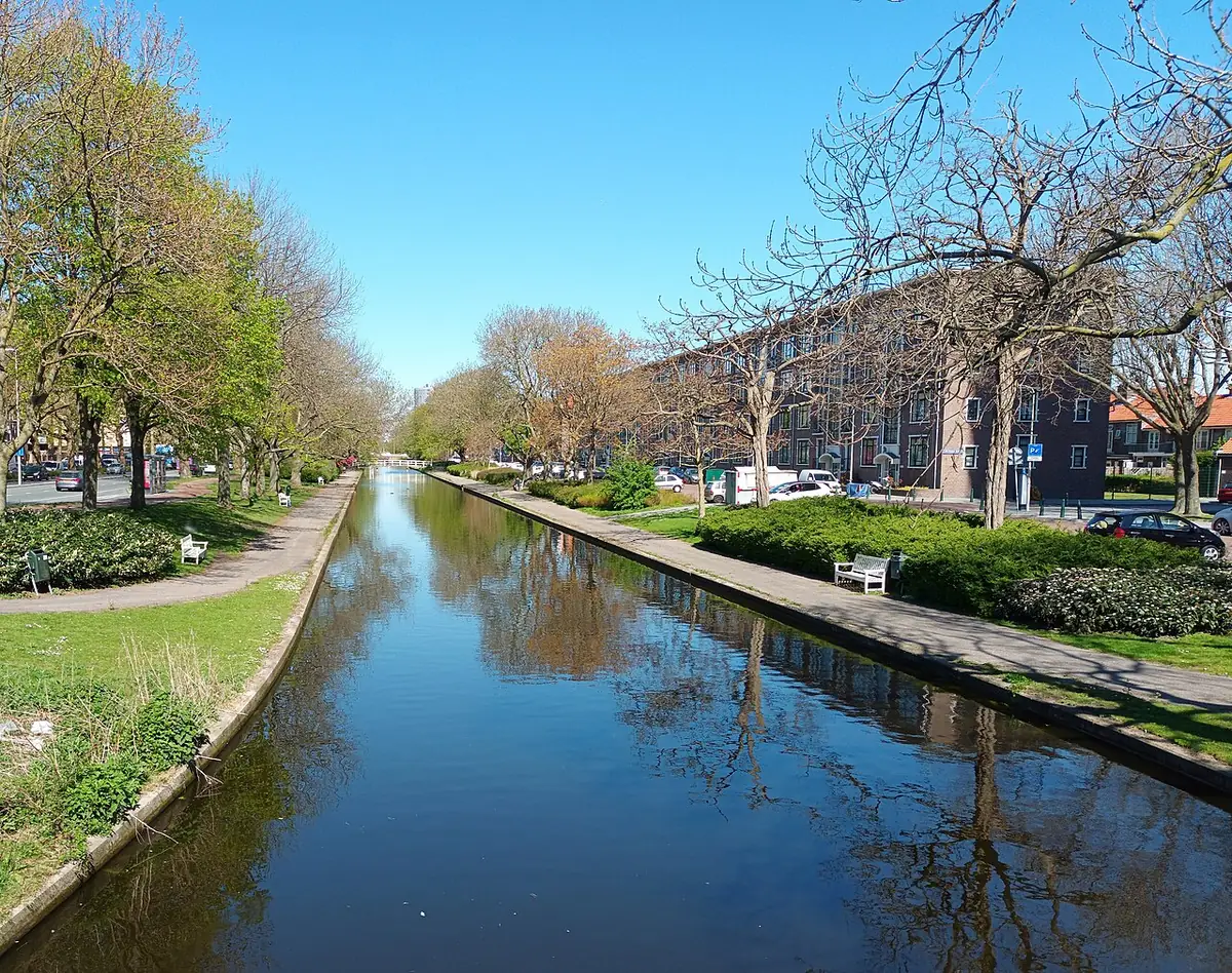 Le canal Lange Laak bordé d’arbres et de pelouses, sous un ciel bleu