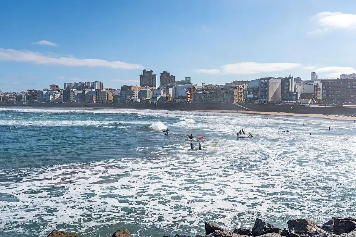Les vagues de la plage de Las Canteras devant une rangée d’immeubles et de tours