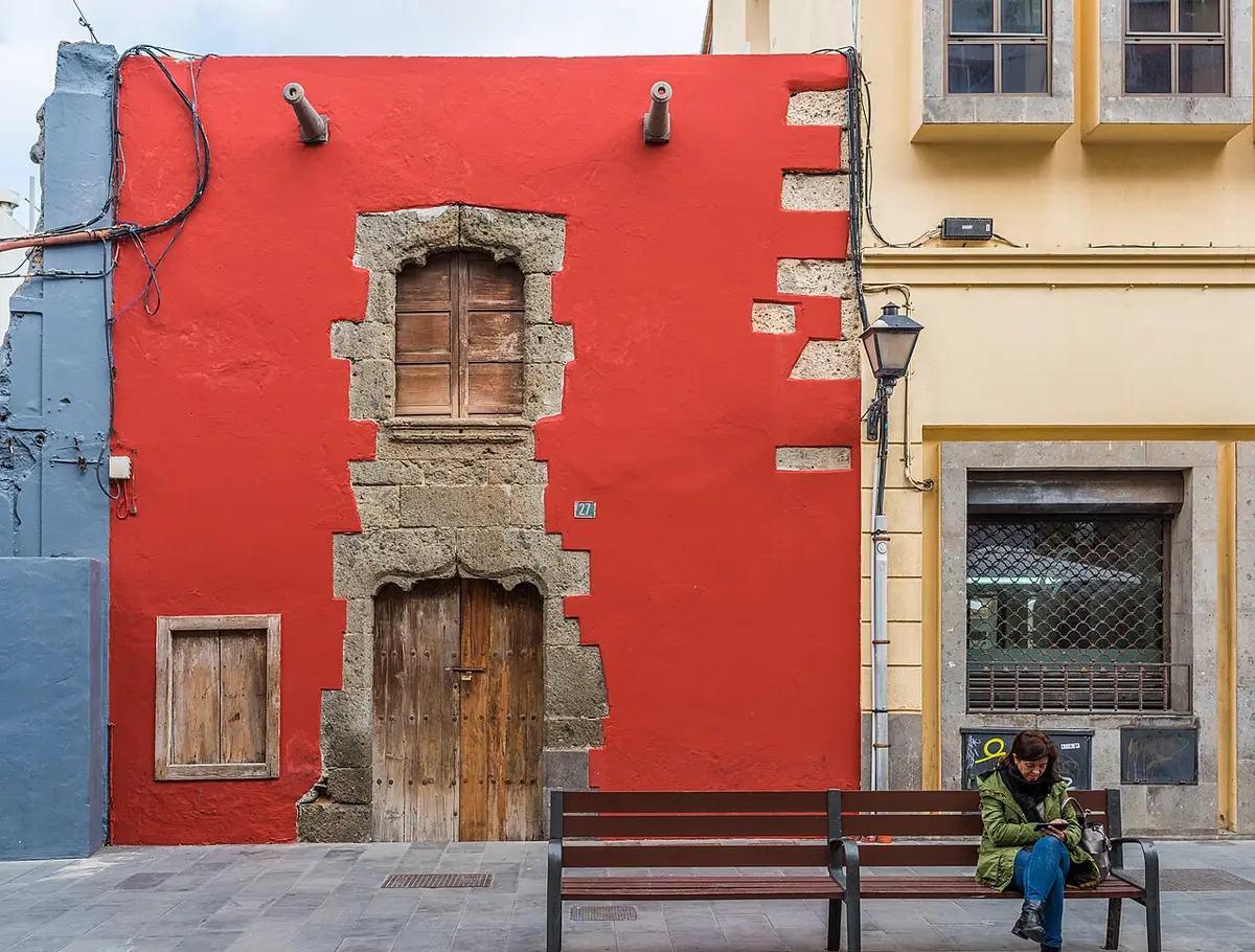 Maison ancienne à façade rouge et encadrements en pierre dans le quartier de Vegueta