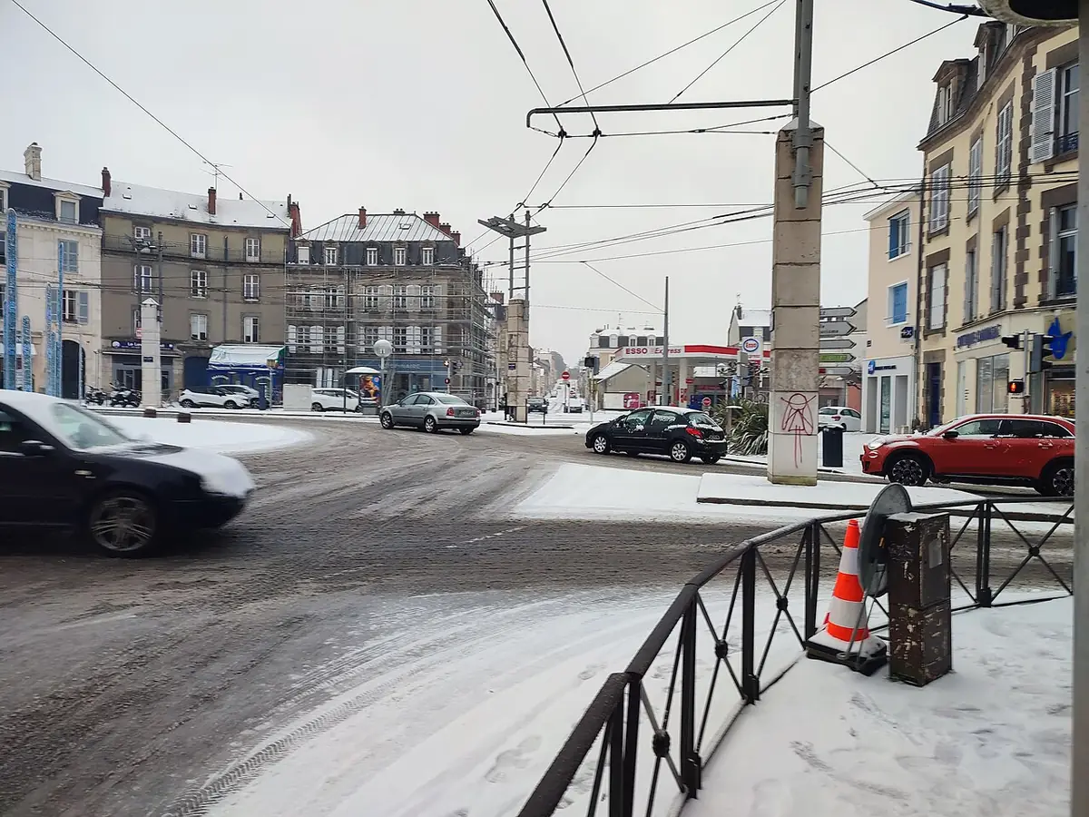 Carrefour enneigé du quartier Carnot-Marceau à Limoges, immeubles et voitures