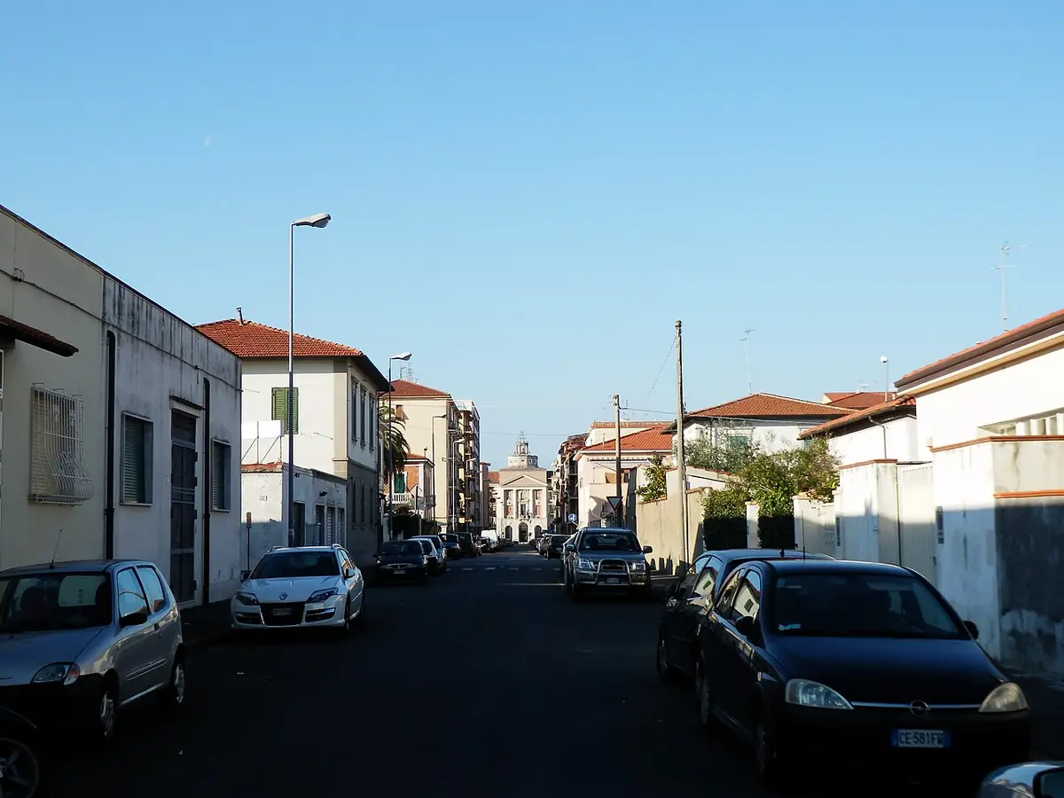 Rue résidentielle de Livourne bordée de maisons basses et de voitures garées