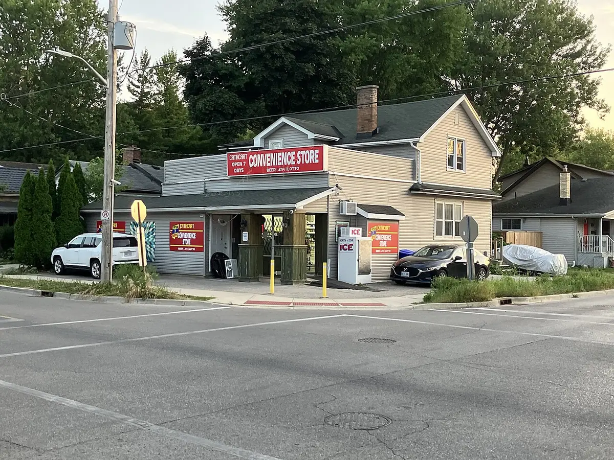Carrefour d’un quartier résidentiel de London avec une petite épicerie de coin et des maisons basses