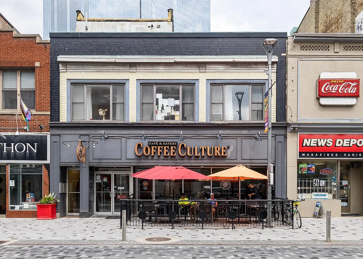 Façade du café Coffee Culture à London (Ontario), terrasse et parasols rouge et orange sur le trottoir