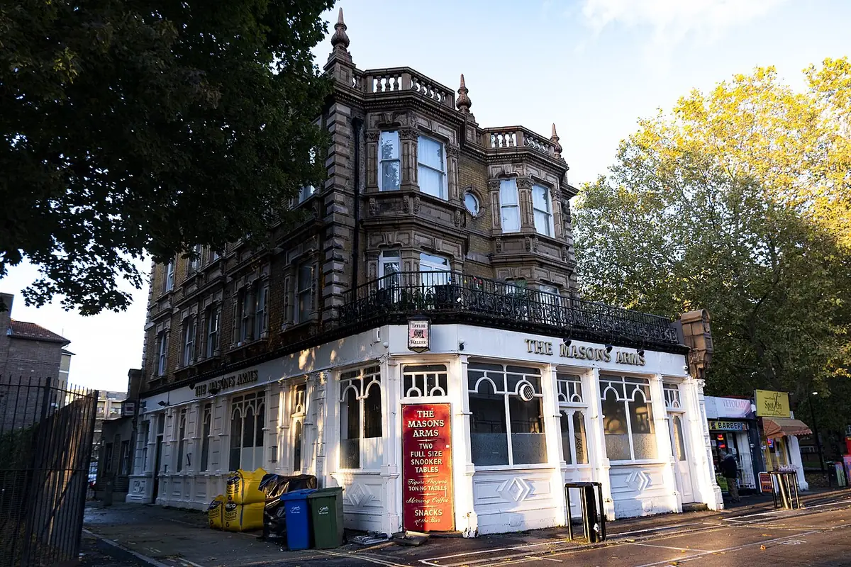An ornate Victorian corner pub with wrought-iron balconies in London
