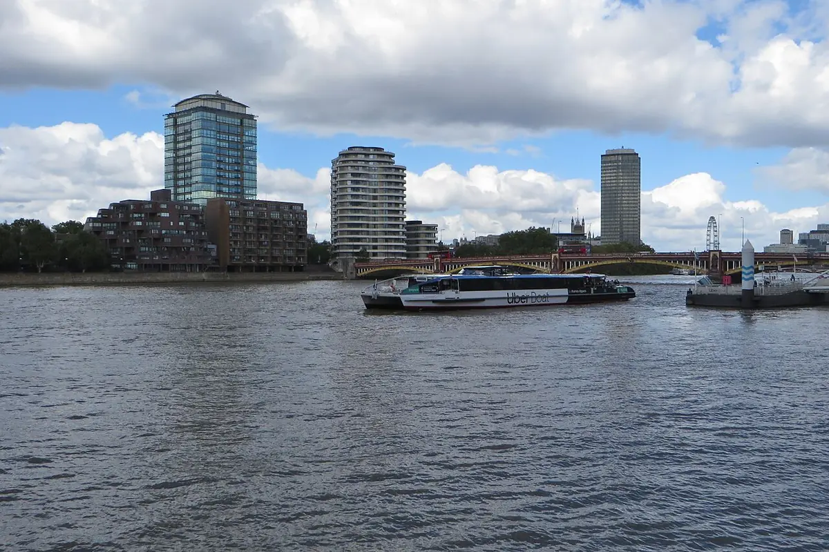 La Tamise près du ponton de St George Wharf, un bateau qui s’éloigne et des tours d’habitation