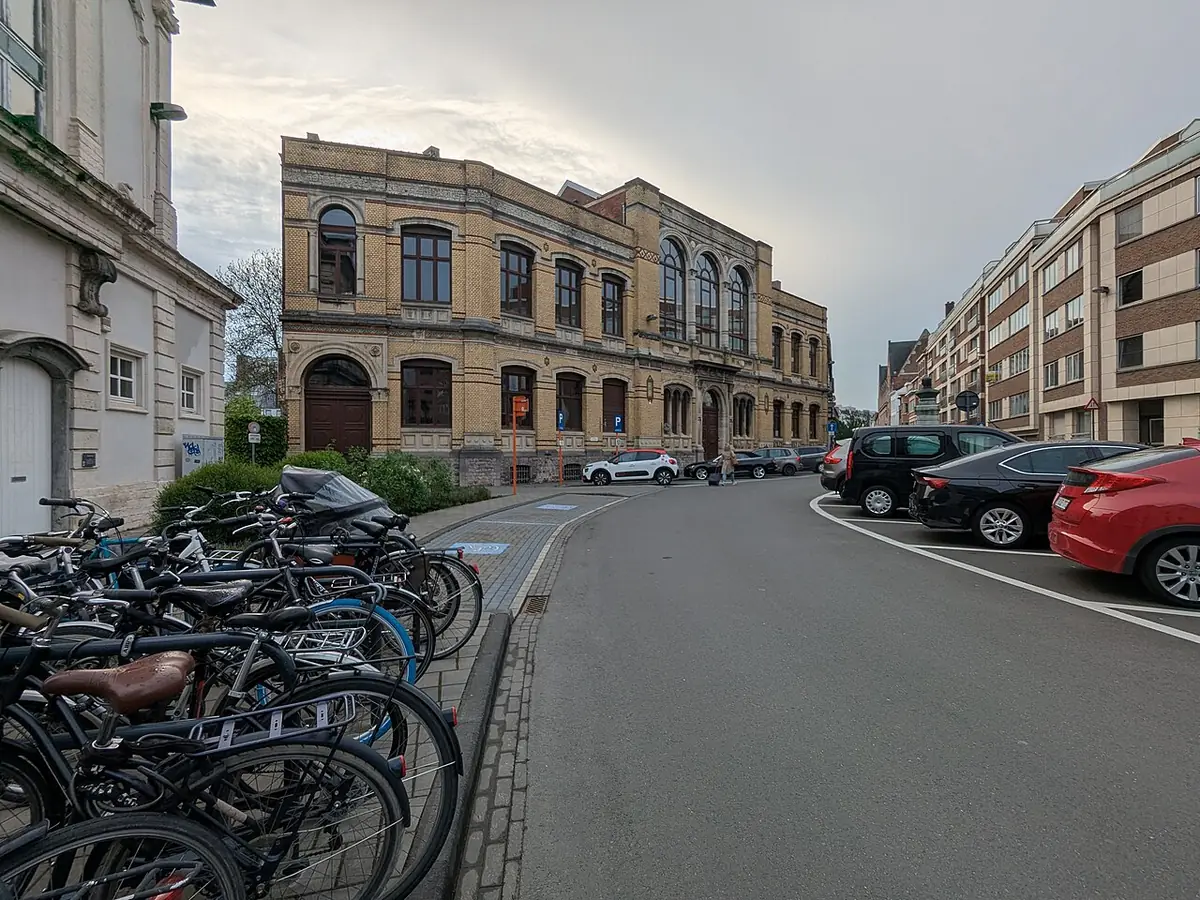 Une rue animée du centre de Louvain, vélos garés le long des façades
