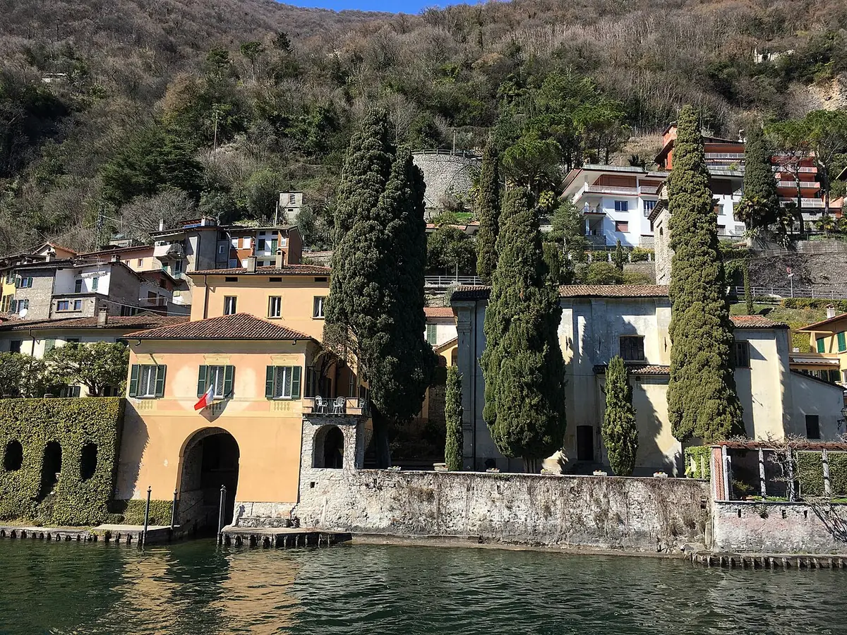 Une ruelle bordée de maisons et de cyprès au bord du lac de Lugano