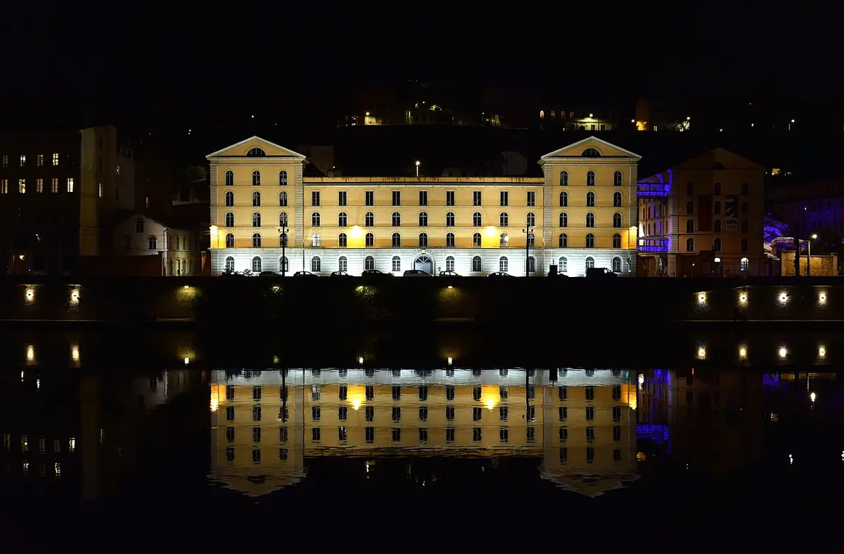 L’Hôtel-Dieu illuminé la nuit, reflété dans le Rhône, à Lyon
