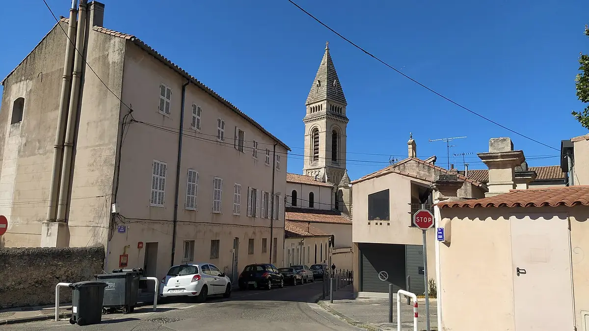 Une rue de Marseille bordée de bâtiments anciens et d’un clocher