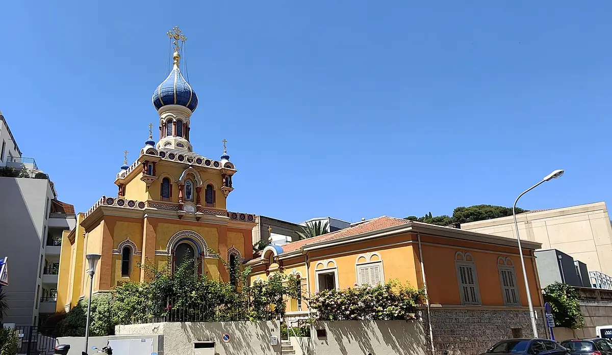 L’église russe de Menton, bâtiment jaune à bulbe bleu, près d’une maison orange