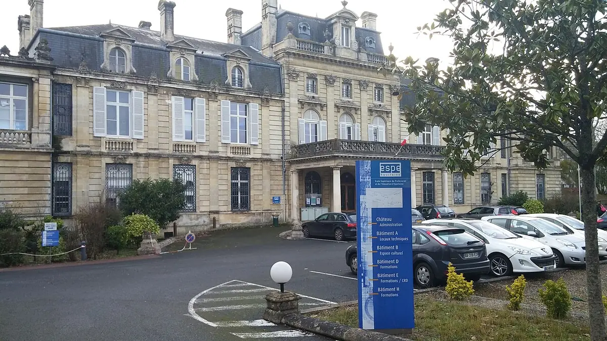 Bâtiment de l’ESPE d’Aquitaine, château en pierre à toits d’ardoise, voitures garées devant
