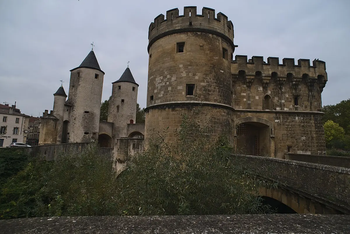 La porte des Allemands à Metz, ouvrage fortifié à tours rondes crénelées et toits pointus, ciel gris