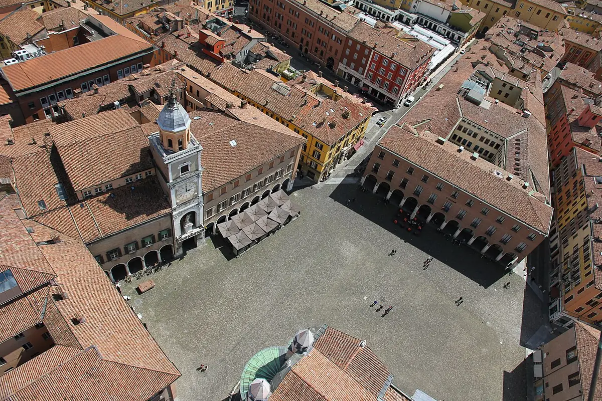 Vue plongeante sur la Piazza Grande de Modène et le palais communal, entourés de toits rouges