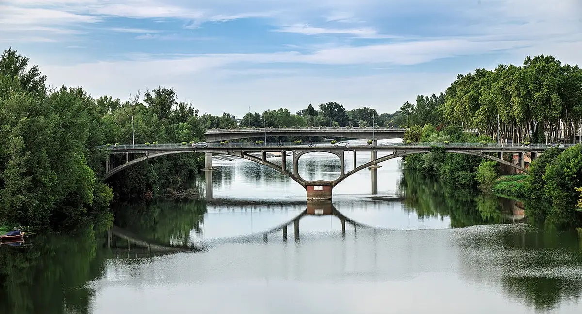 Le Pont Neuf de Montauban vu depuis le Pont Vieux, reflété dans le Tarn entre les arbres