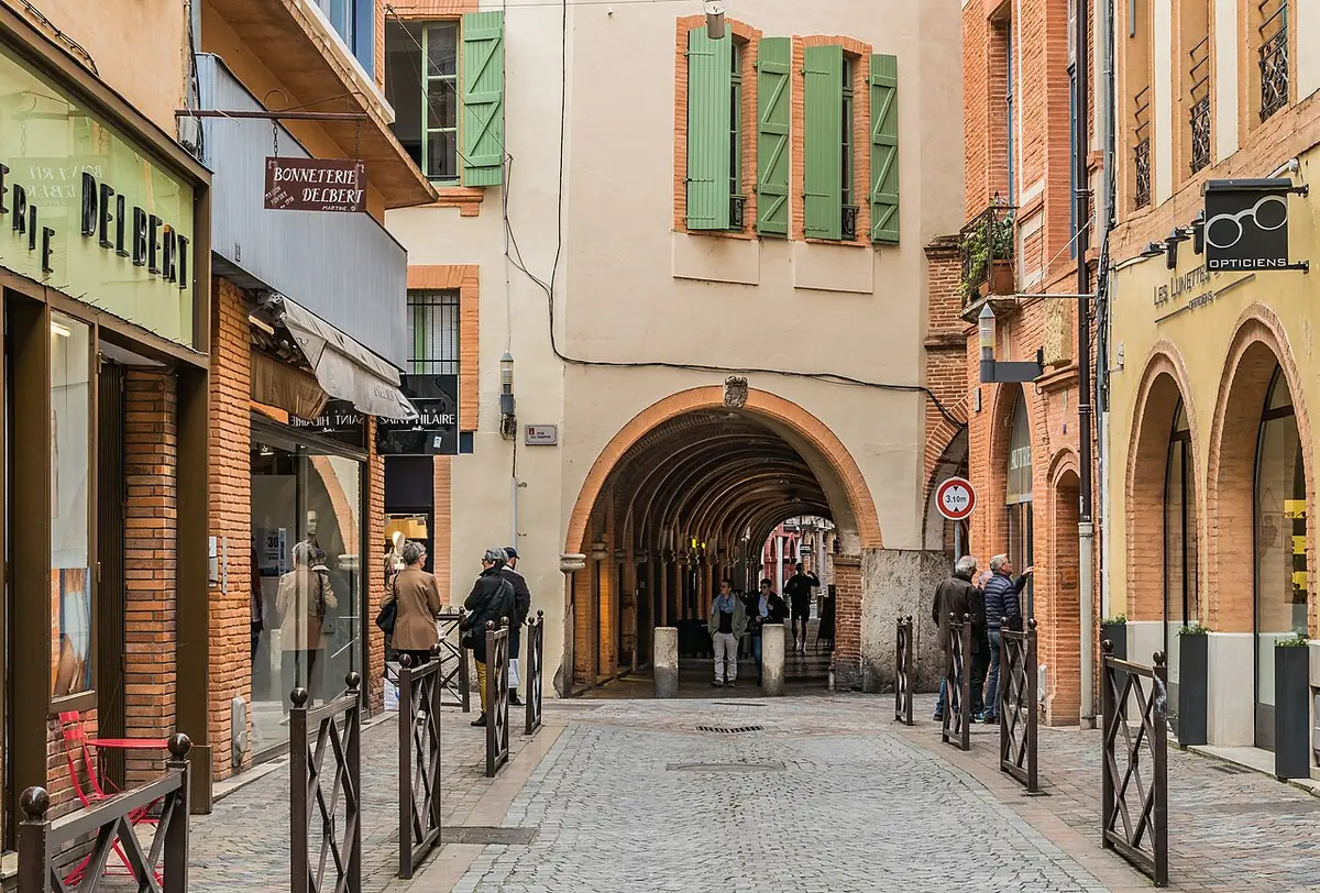 Rue Jules-Michelet à Montauban, façades colorées et passage voûté en brique