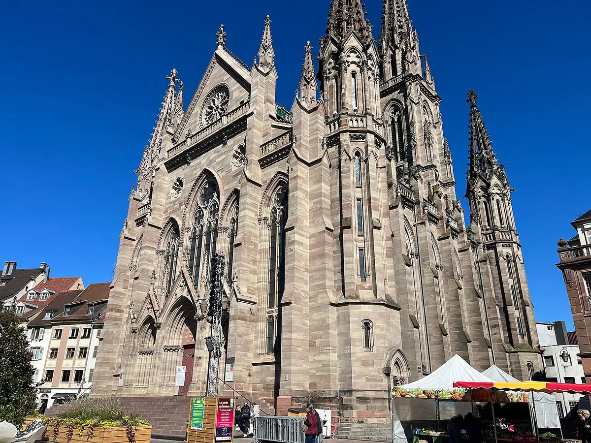 Le temple Saint-Étienne de Mulhouse et ses flèches néogothiques sous un ciel bleu
