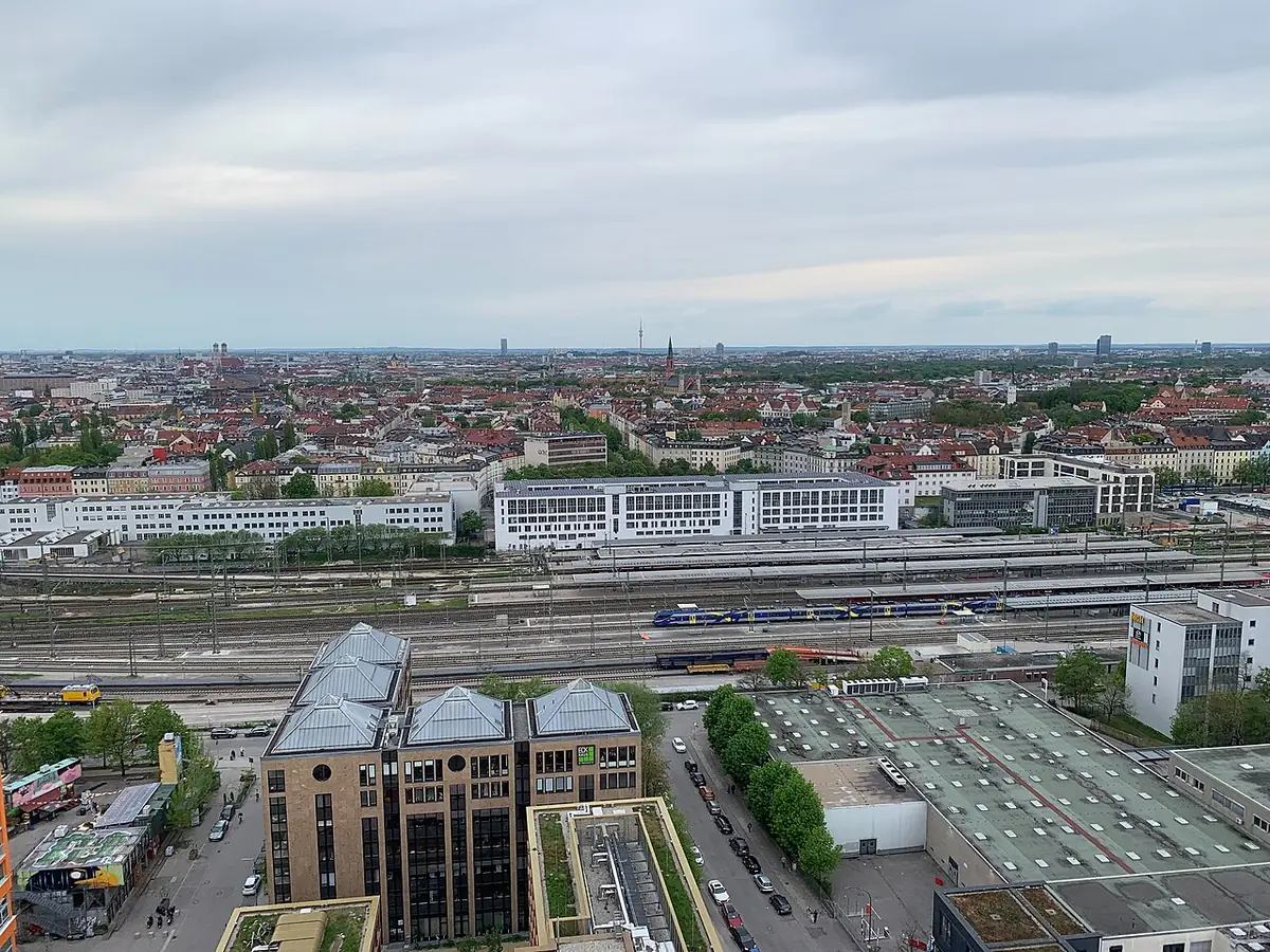 Vue en hauteur sur Munich, la gare de l’Est et ses voies au premier plan, toits de la ville à l’horizon