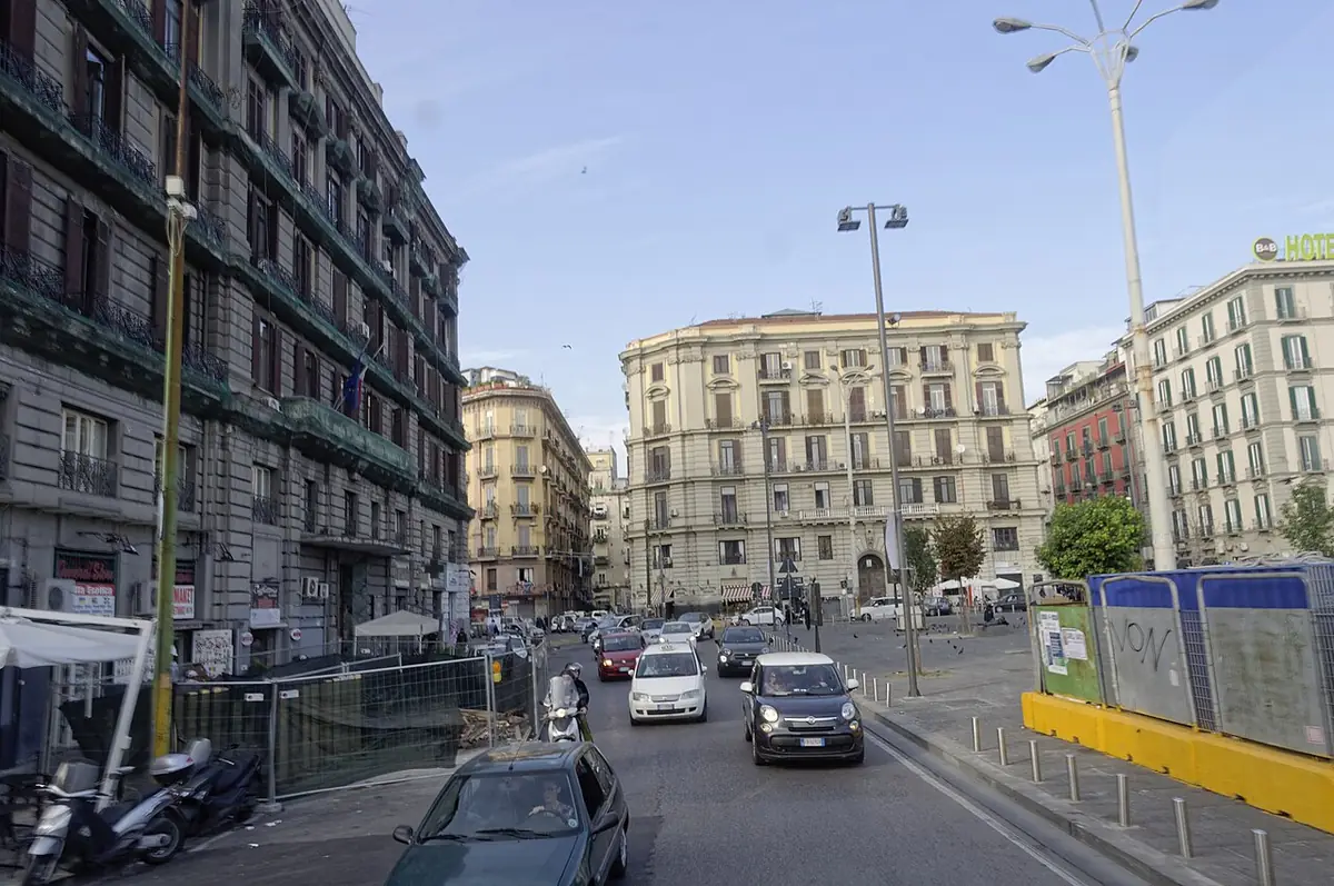 Rue près de la piazza Garibaldi à Naples, voitures et scooters, bordée de grands immeubles anciens