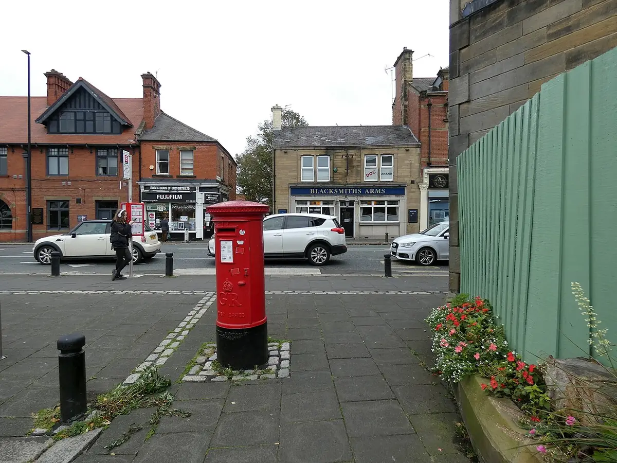 Une rue commerçante à Gosforth avec boîte aux lettres rouge et pub