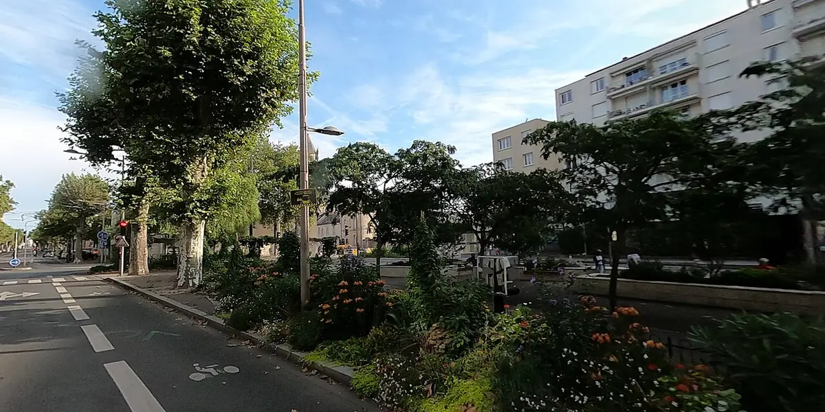 Piste cyclable, arbres et massifs fleuris place Croix Saint-Marceau à Orléans, immeuble d’habitation