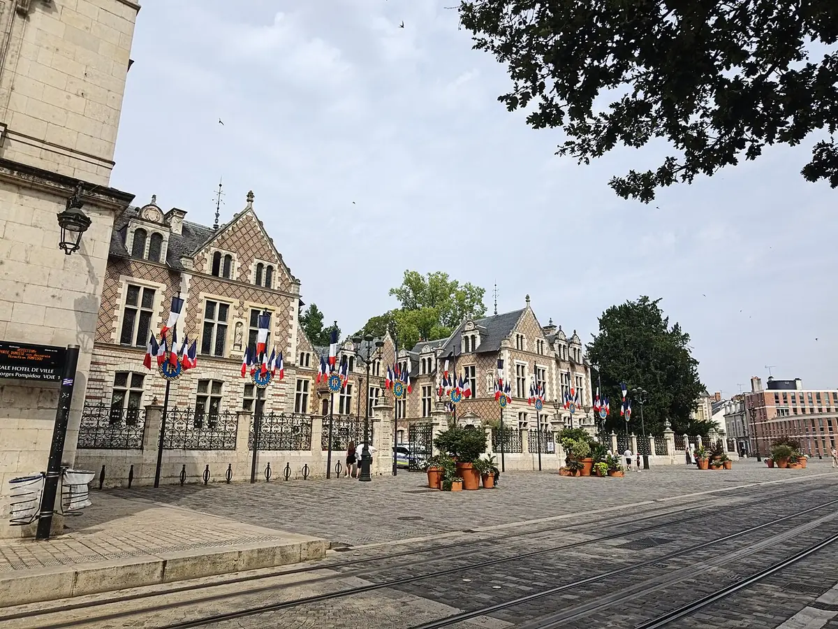 Place de l’Étape et façade en brique de l’hôtel Groslot pavoisée de drapeaux