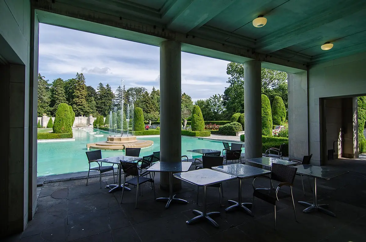 Bassin et fontaine des jardins de Parkwood vus depuis une terrasse couverte à colonnes