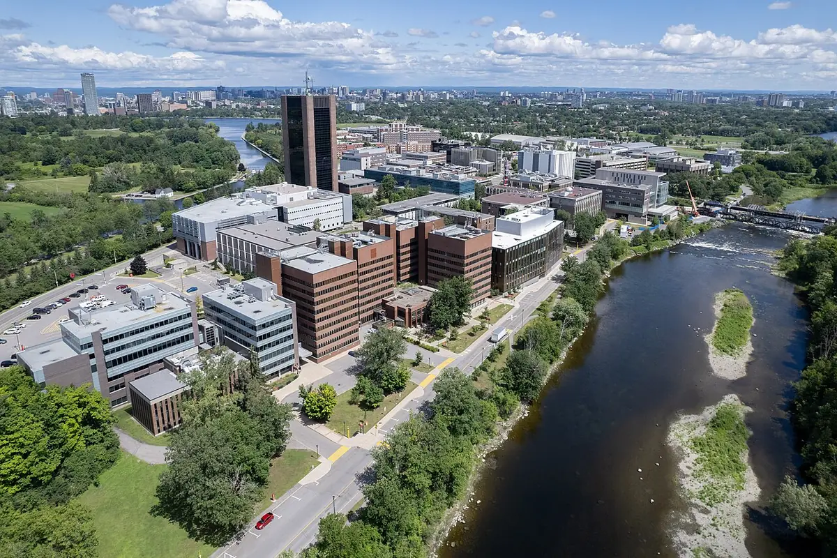 Une vue aérienne d’Ottawa, une rivière serpentant près de bâtiments et d’espaces verts