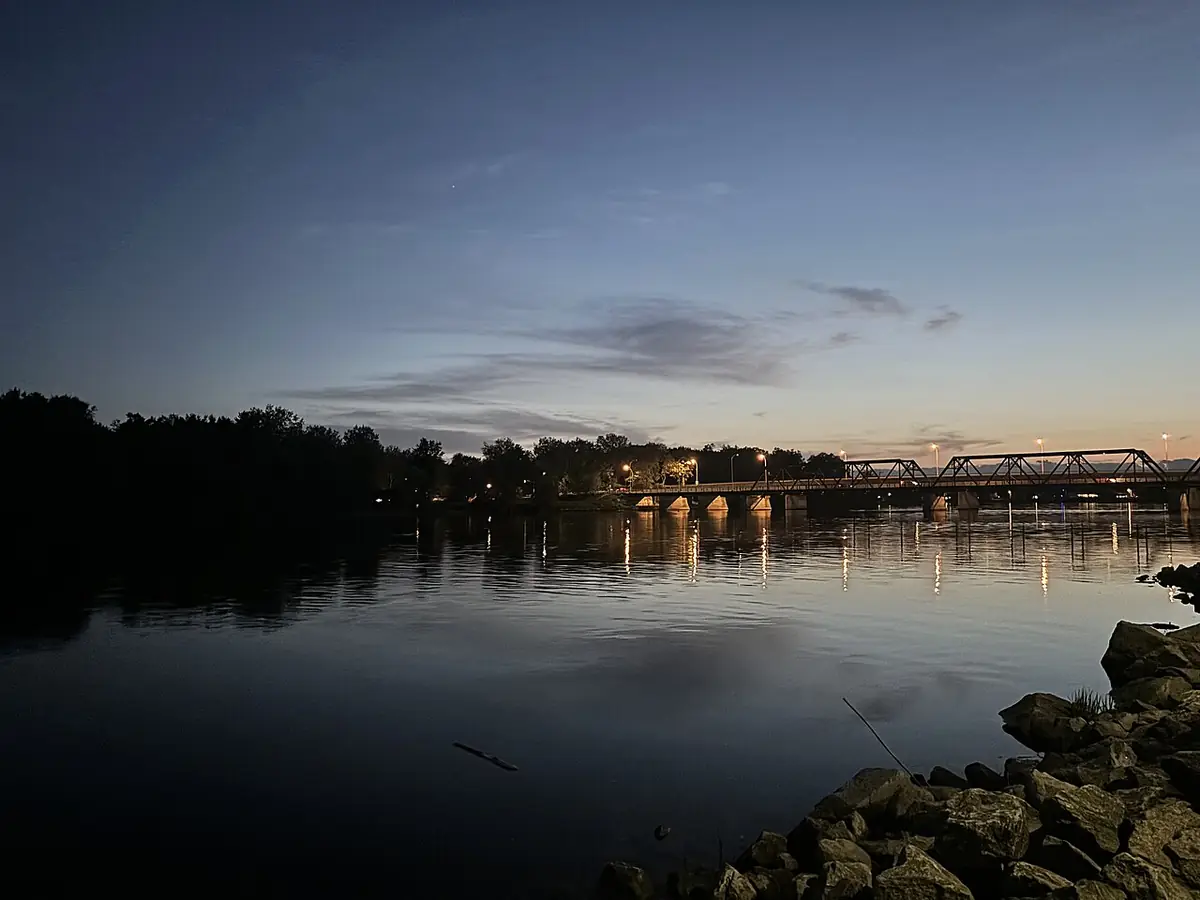 Une rivière au crépuscule près d’Ottawa, un pont illuminé se reflétant dans l’eau calme