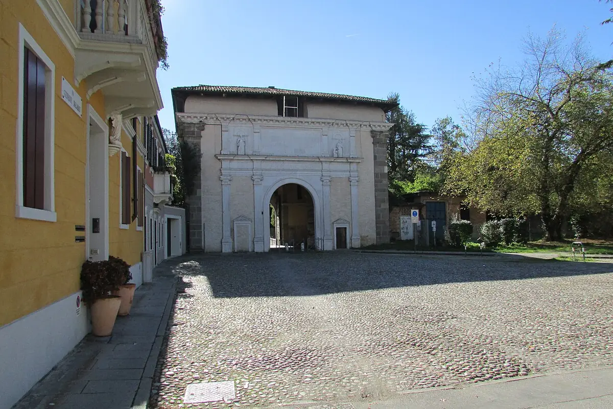 La porte Santa Croce à Padoue, arche de pierre blanche au bout d’une place pavée