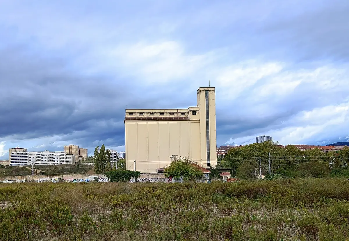 Le silo de Pampelune dressé au-dessus d’un terrain en friche, immeubles au loin
