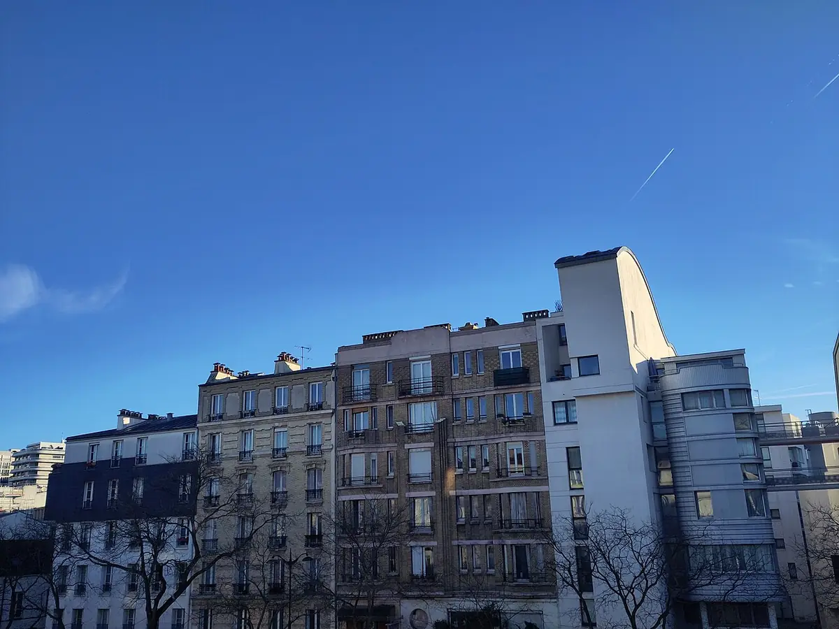 Une façade d’immeuble haussmannien sous un ciel bleu parisien