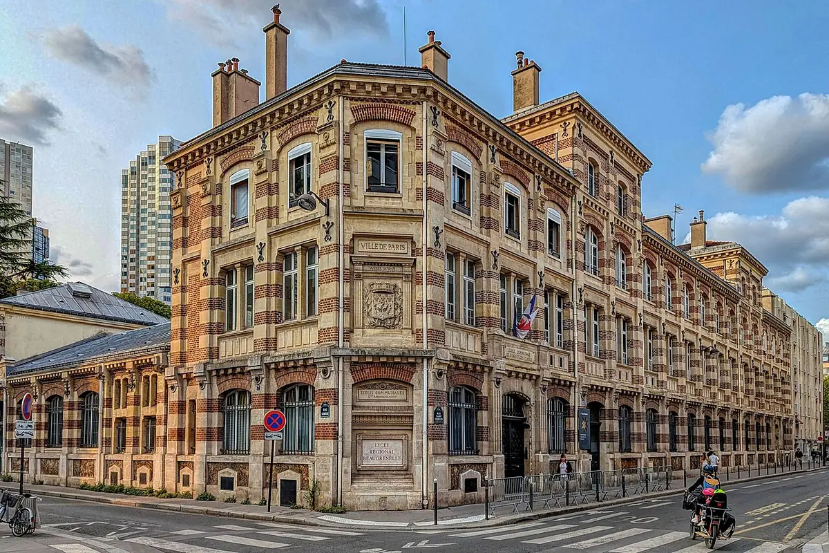Immeuble d’angle en briques du quartier Beaugrenelle, façade ouvragée sous un ciel bleu