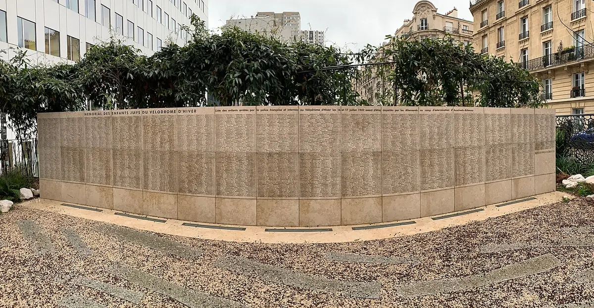 Le Mur des enfants déportés, un mémorial en pierre entouré de verdure