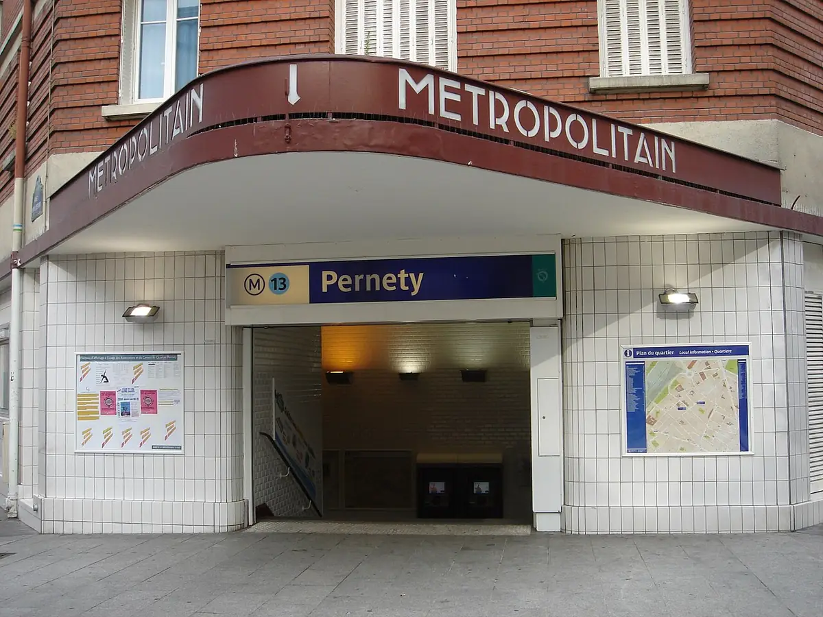 L’entrée du métro Pernety, sous un auvent rouge, entourée d’immeubles