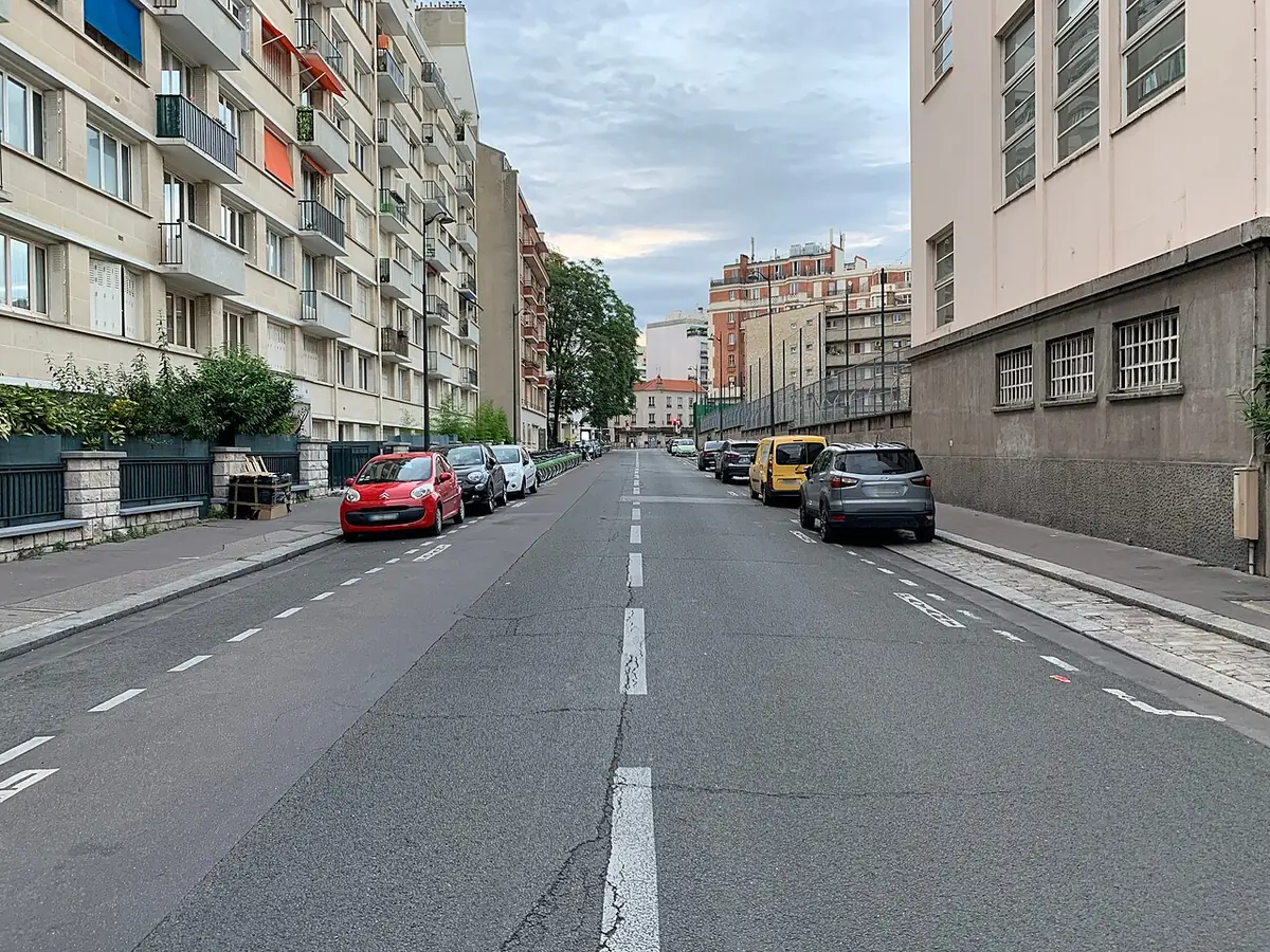 Une rue avec piste cyclable bordée d’immeubles clairs