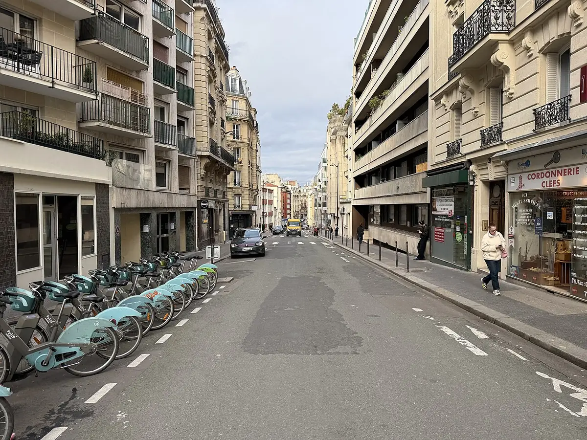 La rue Olivier-de-Serres animée, avec vélos en libre-service et commerces