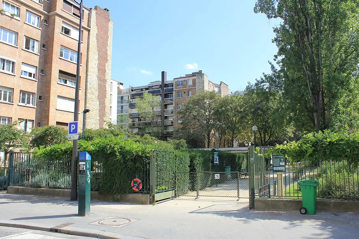 Un chemin dans un square avec des immeubles en arrière-plan