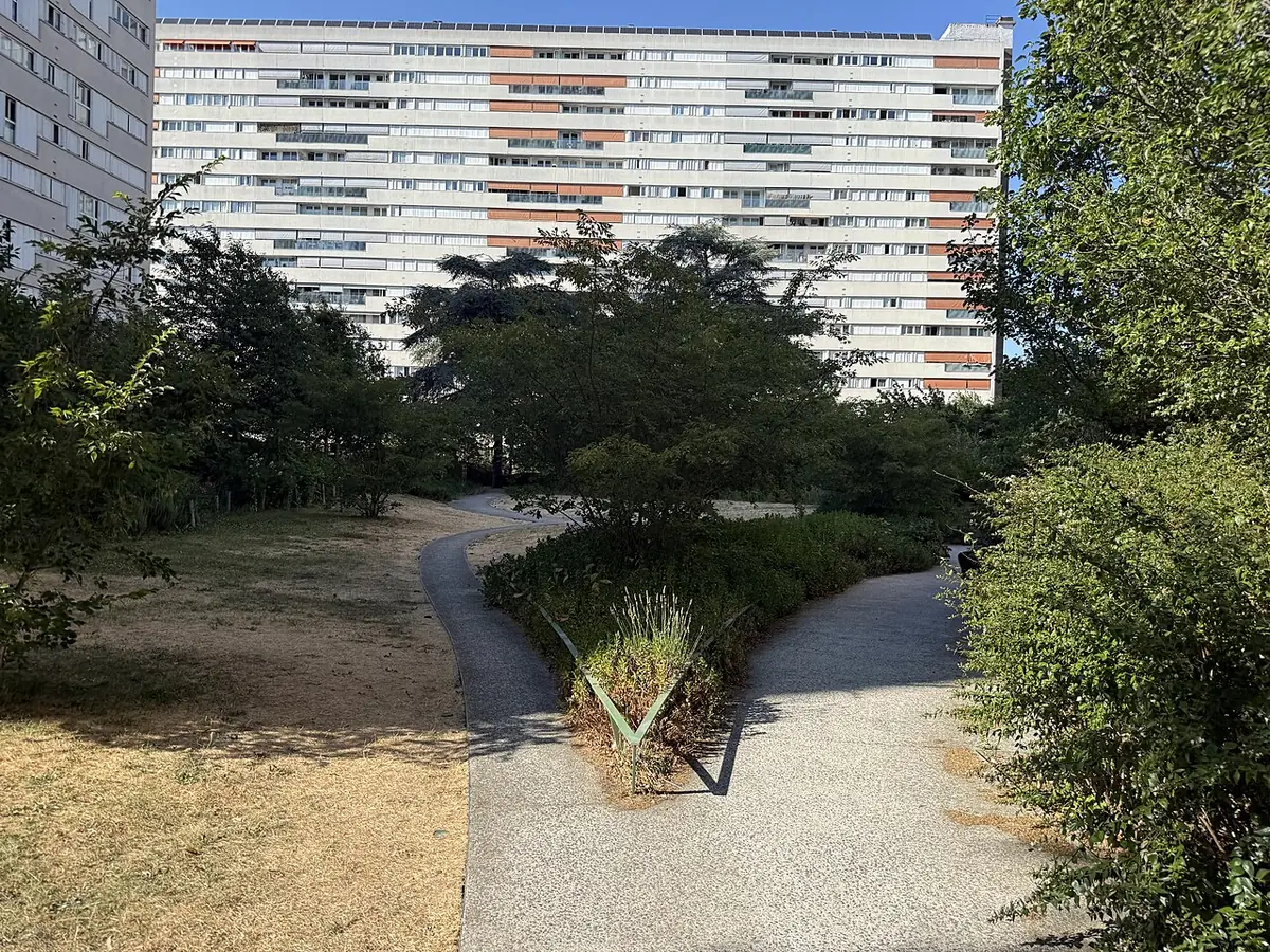 Une allée du square des Périchaux, avec un immeuble moderne en arrière-plan