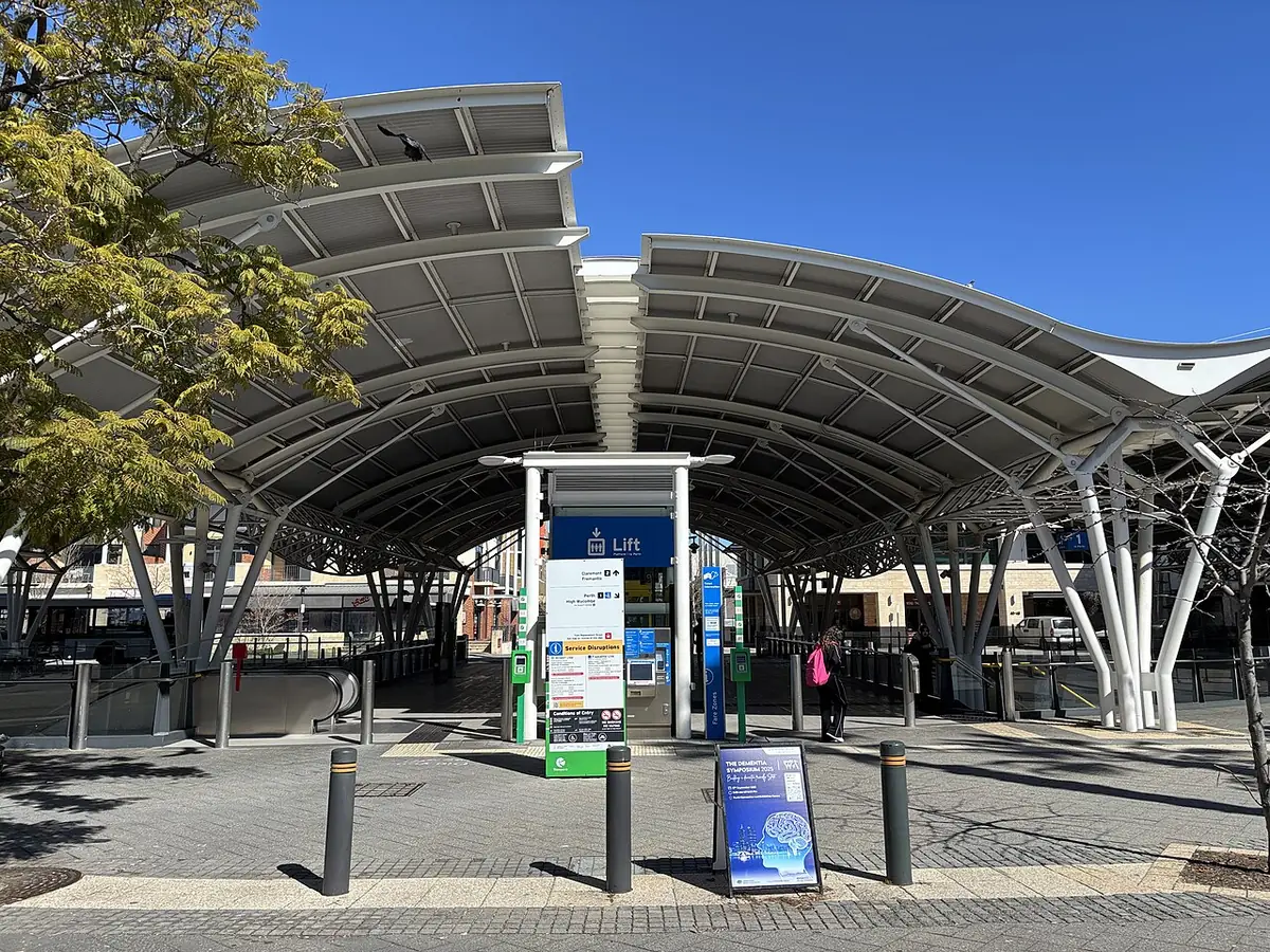 L'entrée de la gare de Subiaco, son auvent courbe et des arbres sous un ciel bleu