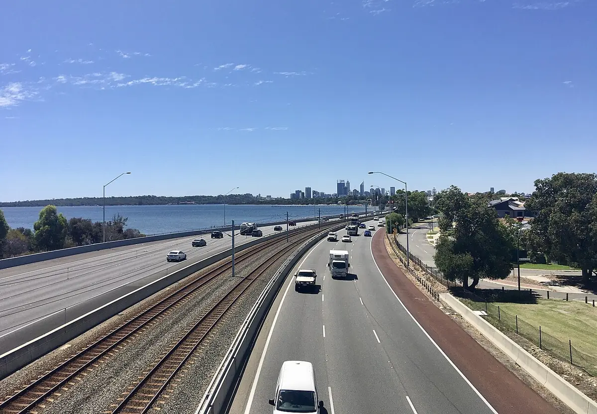 L'autoroute de Kwinana et la voie ferrée à Como, avec la rivière Swan et les tours de Perth au loin