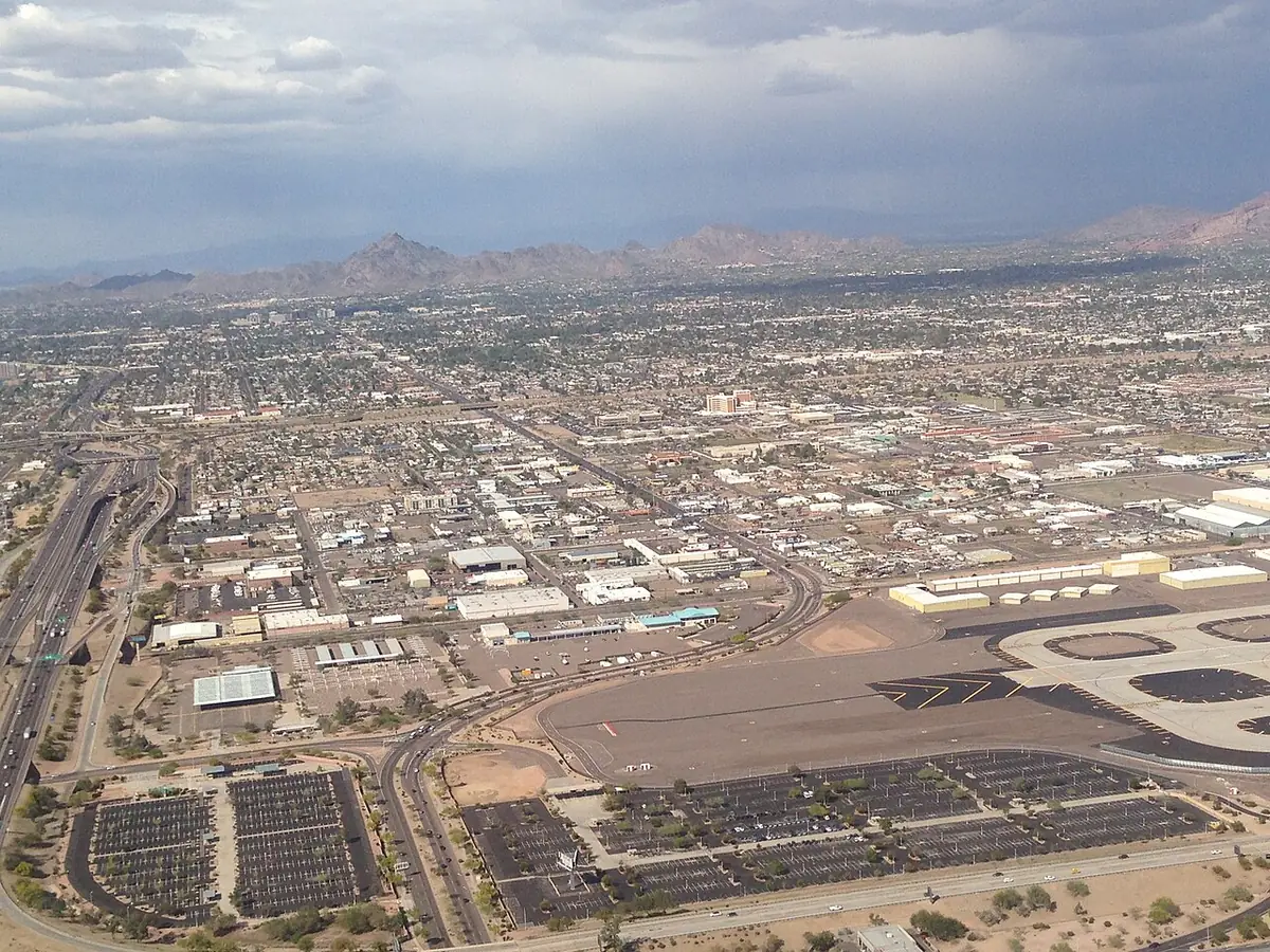 Une vue aérienne voilée sur les toits et rues de Phoenix, avec une montagne à l’horizon