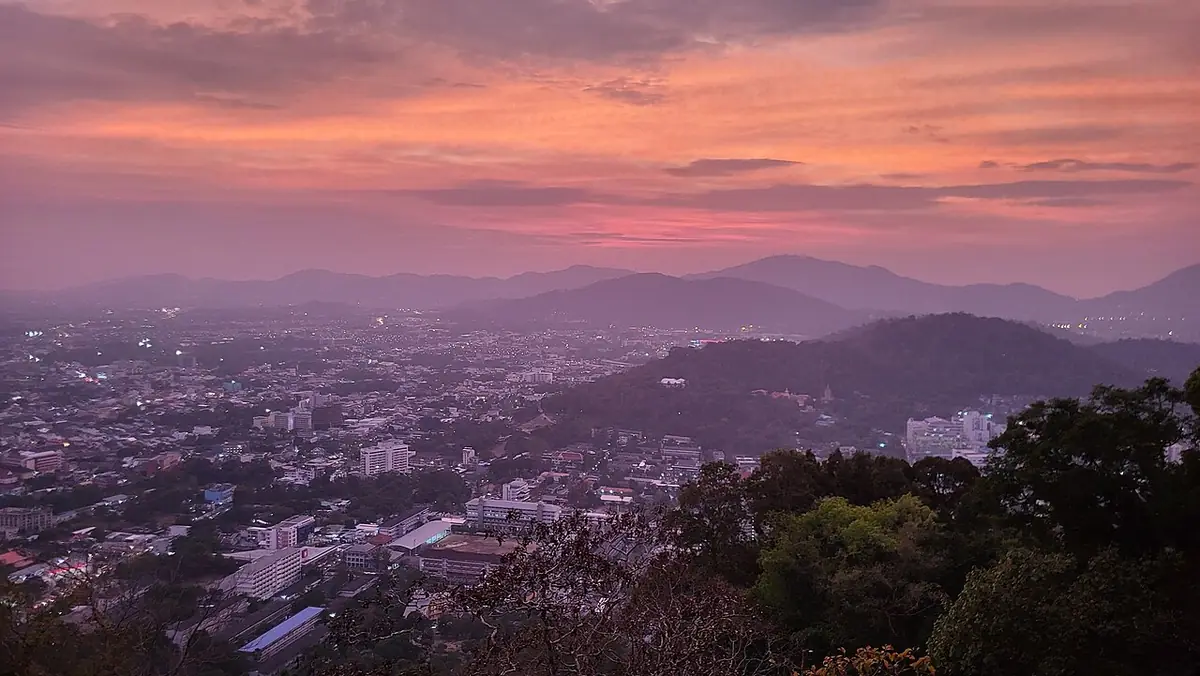Les toits et collines de Phuket baignés d’une lumière rose du soir, vus d’un point de vue en hauteur