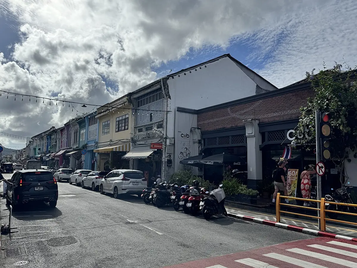 Une rue de maisons-boutiques sino-portugaises dans la vieille ville de Phuket, voitures et motos garées